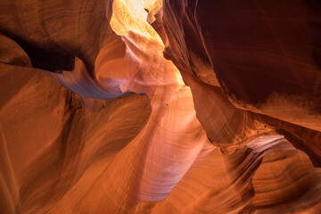 Sunlight streams into Antelope Canyon, illuminating the sandstone walls and creating a stunning display of light and shadow.