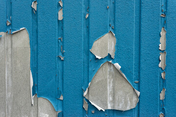peeling blue paint from a steel container wall