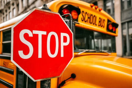School bus safety feature highlighted with red stop sign, photographed in the city. Back to school concept. - Powered by Adobe