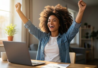 Excited young woman celebrating a significant achievement while working on her laptop at a desk with a bright window