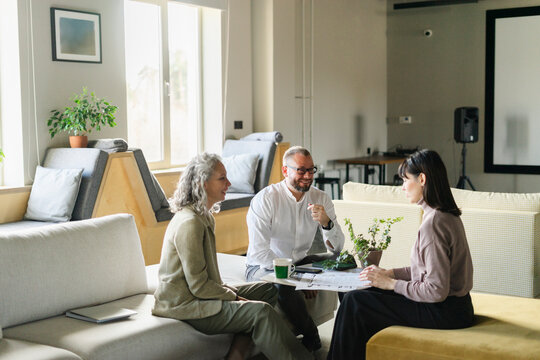Businessman and businesswoman having a meeting with client in office