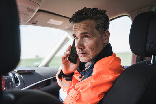 Engineer talking on mobile phone sitting in car