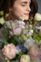 Naklejka premium Young caucasian female with floral bouquet contemplating peacefully