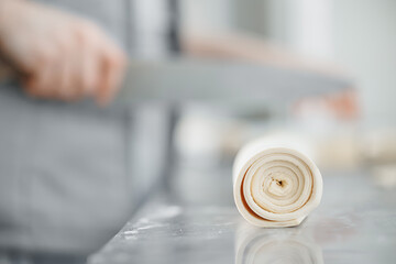 Closeup of rolled dough ready for baking preparation in industrial bakery