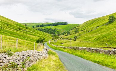 Yorkshire Dales in Summertime.  A single track, winding road leading from Kettlewell in Wharfedale over moorland and into Coverdale, North Yorkshire, UK. Horizontal  Copy space
