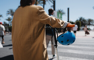 Woman crossing road with e scooter