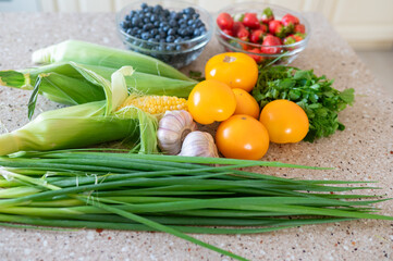 Fresh vegetables and berries on kitchen counter in natural light