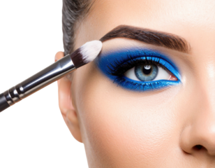 Close-up of a woman applying vibrant blue eyeshadow with a brush on her eyelid, highlighting detailed eye makeup and smooth skin texture.