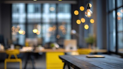 Fototapeta premium Blurred modern office interior with wooden table and yellow accents. Warm bokeh lights and glass windows. Creative focus and productivity. Banner for corporate websites.