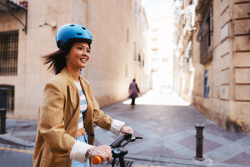 Asian woman using electric scooter and exploring Spanish town