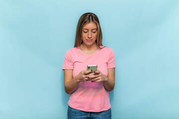 Woman wearing pink for Breast Cancer Awareness using smartphone on blue background