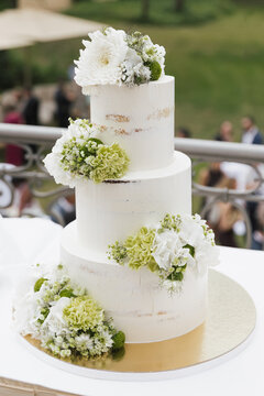 white modern minimalist wedding cake with white and green flowers