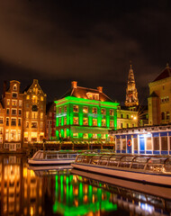 Naklejka premium Reflections in the canal at night - a beautiful Amsterdam night scene from the Damrak 