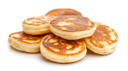 Photograph of round, golden-brown pancakes stacked on a white surface, likely varenyky or blini.