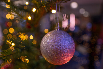 Christmas bauble On Christmas Tree With traditional Ornaments, christmastime Moments, blur festive background, Bokeh effect garlands