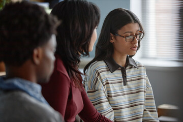 Multiethnic group of teenagers attending counseling session, Black teenage boy and Asian teenage...