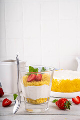 Classic cheesecake in glass, with fresh strawberry and golden cookie crumble