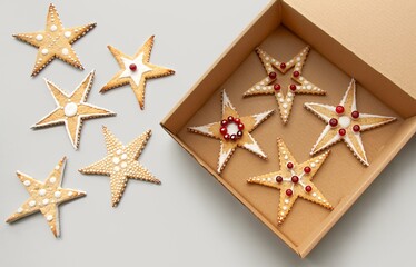 Christmas cookies in a paper box. Frosted Sugar. Star shape cookies with painted patterns. Christmas gifts, sustainable packaging concept. Negative space