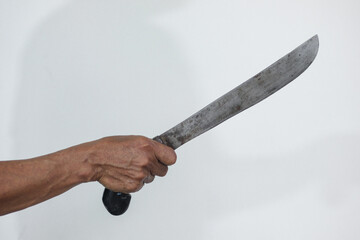 Hand holding sharp machete. Symbolizes danger, violence, and aggression. Ideal for themes of crime, self-defense, or survival.
