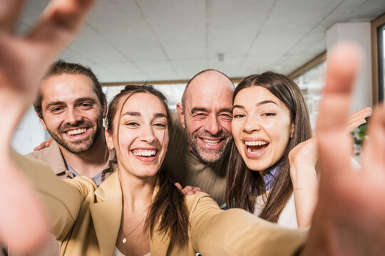 Happy cheerful business colleagues taking selfie at office