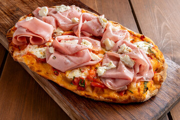 Pinsa romana con base pomodoro, mozzarella e mortadella, cibo italiano 