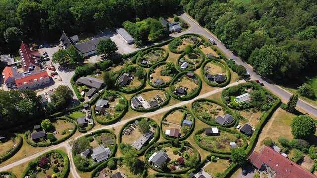 Aerial view of The round gardens showing lush green vegetation and unique circular garden plots with small houses, Naerum, Naerum, Denmark.