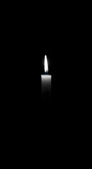 Fototapeta premium Single candle on dark background with soft glow