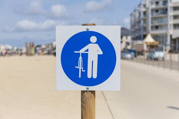 Un panneau indique que les cyclistes doivent descendre de leur vélo.