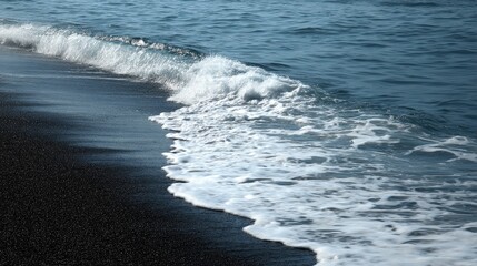Fototapeta premium Foamy waves lapping at a dark beach.