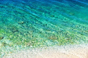 Turquoise clear sea surface in nuances of blue on the beach summer background