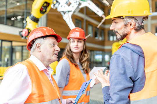 Senior colleague in work wear having meeting with skilled workers