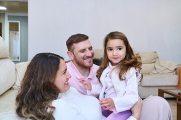 Happy latin family expecting a new baby is having fun at home