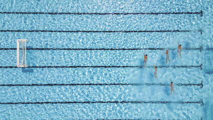 Aerial view of the shimmering blue pool water reflecting the sunlight as swimmers glide through the lanes, Split, Split-Dalmatia County, Croatia.