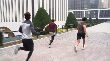 Group of male athletes running in urban environment