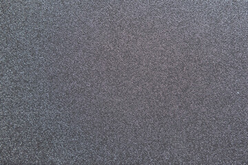 close-up of a dark gray textured surface with fine, subtle glitter. The uniform sparkle