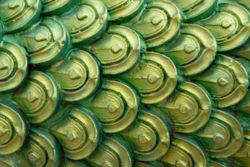 close-up of ornate, metallic green and gold scales, reminiscent of a dragon or the mythical Naga...