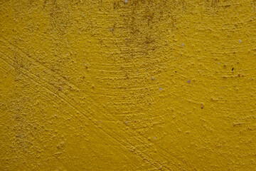 close-up shot of a textured gold yellow concrete surface. The rough and slightly uneven texture, along with subtle variations in the gold yellow hue, creates a visually interesting background.