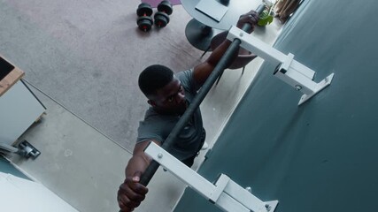 High angle shot of strong young African American man doing pull ups while working out at home - Powered by Adobe
