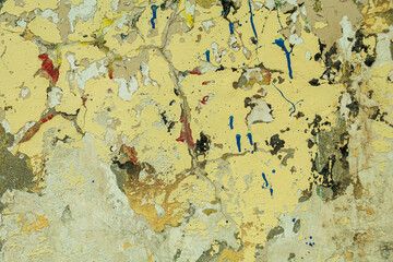 Abstract: crumbling graffiti on a city street wall. Colorful abstract background. Old, cracked, peeling paint serves as a background.
