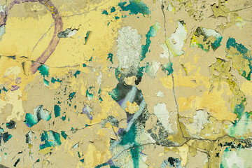 Abstract: crumbling graffiti on a city street wall. Colorful abstract background. Old, cracked, peeling paint serves as a background.