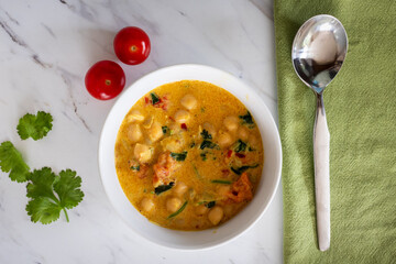 Homemade spicy chickpea Indian curry soup with tomatoes coconut milk coriander garnish