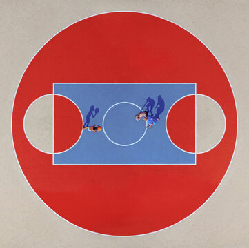 Aerial view of a vibrant basketball court with bold red and blue hues, where elongated shadows stretch from two figures, Kharkiv, Kharkiv Oblast, Ukraine.