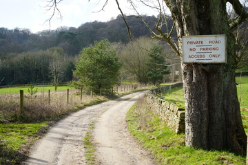 North East Derbyshire, England - March 6 2024: Scenic view of a winding country lane with dry stone...