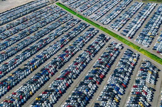 Fototapeta Aerial drone view of Parking lots. New hybrid or electric cars storage area. Many colorful cars parked in a rows 