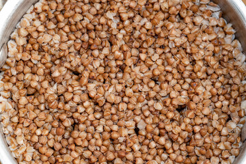 Plate with tasty buckwheat porridg.Boiled buckwheat porridge in ceramic pot on wooden background.