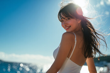 Smiling woman in white dress / white swimsuit by the sea on a sunny day