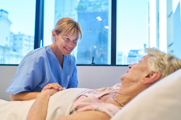 Nurse providing compassionate care to an elderly woman in a rehabilitation facility