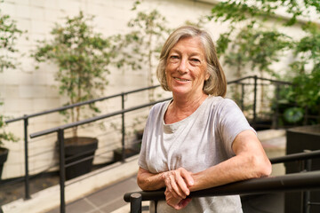 Smiling older woman enjoying outdoor time at a senior care facility garden