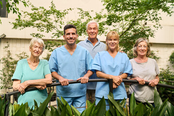 Friendly staff and seniors enjoying nature at a rehabilitation facility