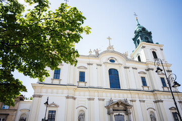 Historic baroque church of the Holy Cross facade with intricate details under a clear blue sky. Warsaw, Poland.
